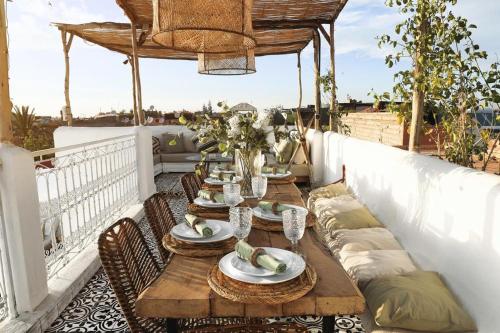 drewniany stół na balkonie z krzesłami i tableablish w obiekcie Riad SHIRAZ w Marakeszu