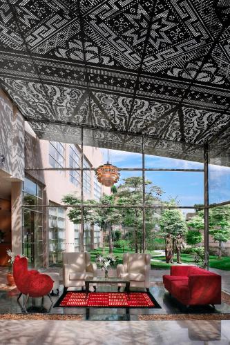 a living room with a couch and a red chair at PULSE GRANDE Hotel Putrajaya in Putrajaya