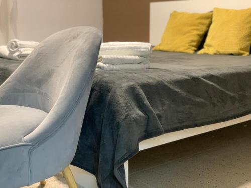 łóżko z niebieskim kocem i krzesłem w obiekcie GREEN APARTMENT BY ALEX RAFAEL w Zagrzebiu