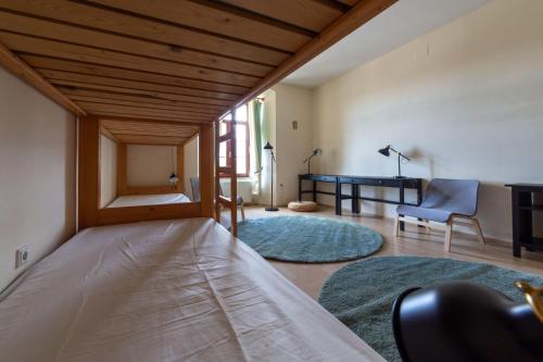 a bedroom with a bed and a desk in a room at Samostan Mekinje in Kamnik