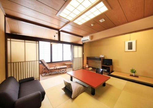 a living room with a couch and a table at Saikatei Jidaiya in Kaminoyama
