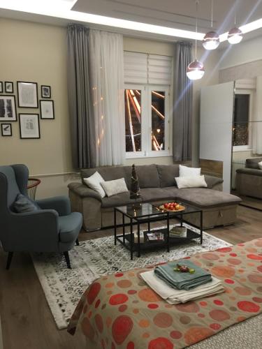 a living room with a couch and a table at Visit Debrecen Apartman in Debrecen