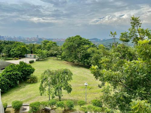 a large grassy field with trees and a city in the background at PULSE GRANDE Hotel Putrajaya in Putrajaya