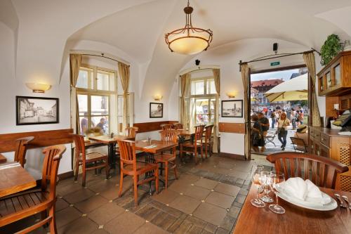 a restaurant with tables and chairs and people walking around at Hotel Lippert in Prague