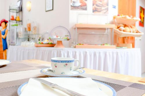a table with a cup and a plate on a table at Gästehaus Engelgasse Herzogenaurach in Herzogenaurach