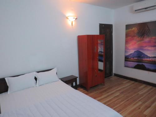 a bedroom with a bed and a painting on the wall at KHÁCH SẠN HƯƠNG SEN PHÚ YÊN in Tuy Hoa