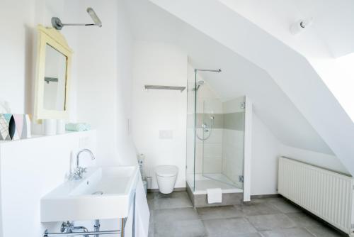 a white bathroom with a shower and a sink at Villa Breitenberg in Breitenberg