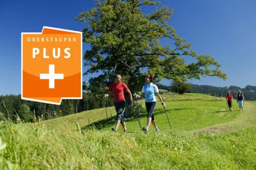 two people walking on a trail near a plus sign at Chalet Saneberg am Hochgrat in Oberstaufen