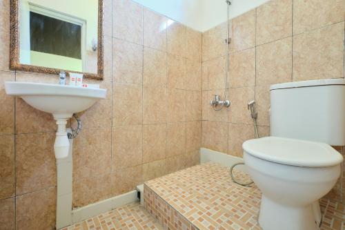 y baño con aseo y lavamanos. en Super OYO 2519 Mayang Garini, en Magelang