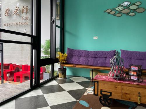 a living room with a purple couch and a checkered floor at Teacher Cai Homeestay in Xiaoliuqiu