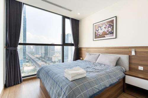 a bedroom with a bed and a large window at Luxury Apartment Vinhomes Skylake in Hanoi
