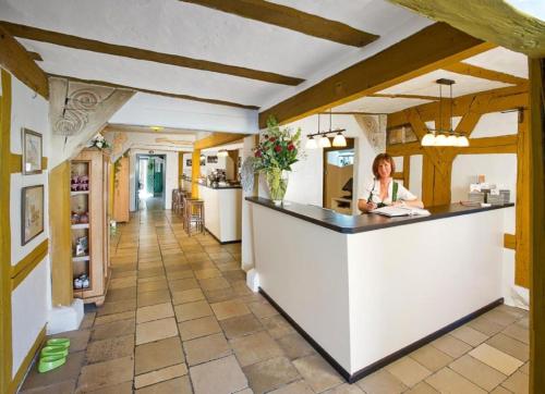 a woman sitting at a counter in a kitchen at DER SCHWAN Hotel & Restaurant in Schwanstetten