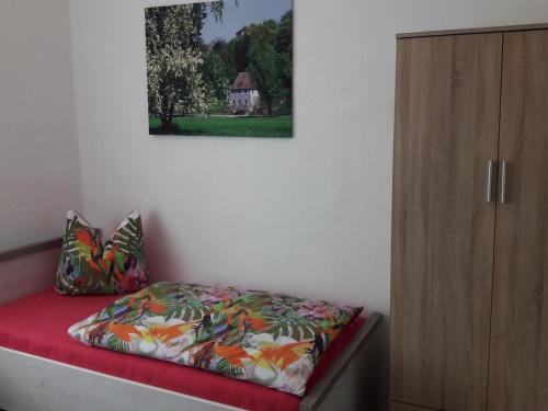 a bedroom with a bed next to a wooden cabinet at Ferienwohnung Hünefeld in Weimar