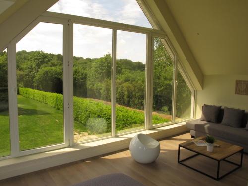 a living room with a large window and a couch at La Garonde in Berthen
