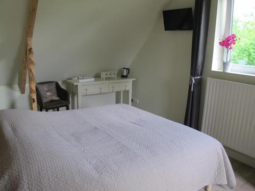 a bedroom with a white bed and a window at La Garonde in Berthen