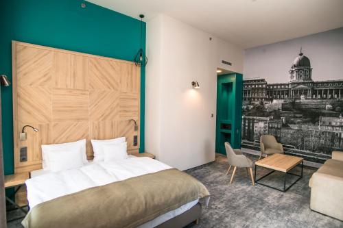 um quarto de hotel com uma cama grande e uma secretária em T62 Hotel em Budapeste