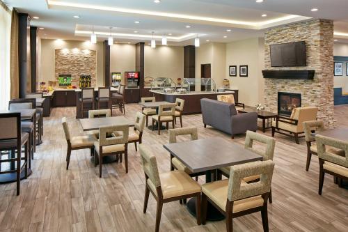 a restaurant with tables and chairs and a fireplace at Staybridge Suites Anaheim At The Park by IHG in Anaheim