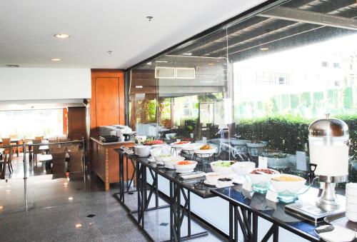 a buffet line with bowls of food in a restaurant at CH Hotel in Chiang Mai