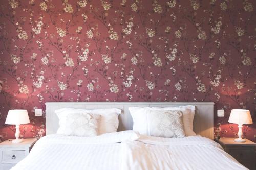 a bedroom with a bed with a floral wallpaper at B&B Nieuwhof in Gistel
