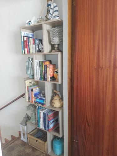 a book shelf filled with books next to a door at Rooftops in Bredasdorp