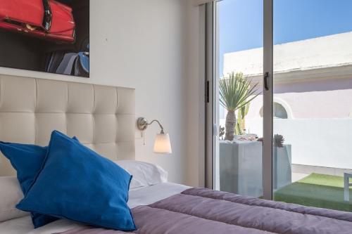 カディスにあるEl Atico del MARQUES free parking by Cadiz4Rentalsのベッドルーム1室(青い枕のベッド1台、窓付)
