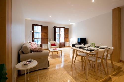 sala de estar con sofá y mesa con sillas en Pucela apartmets en Valladolid