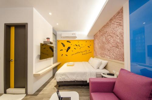 a hotel room with a bed and a couch at 安尼赫時尚旅店 Anich Fashion Inn I 墾丁大街 I 親子遊戲區 I 停車位 in Kenting