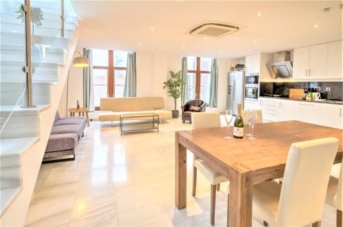 cocina y sala de estar con mesa de madera y sillas en Marble Lodge Apartments in the Center of Antwerp en Amberes
