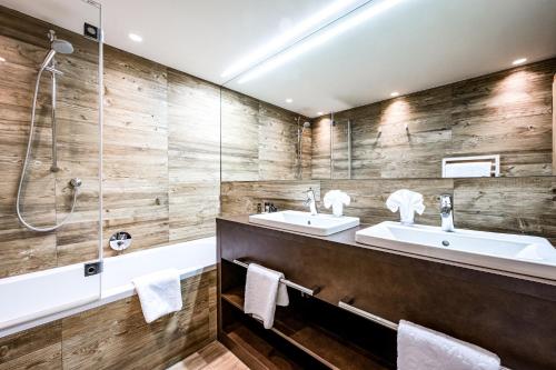 a bathroom with two sinks and a shower at Hotel Edelweiss & Gurgl in Obergurgl