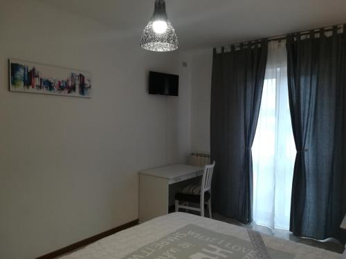een slaapkamer met een bed, een bureau en een raam bij Affittacamere Giada in Gubbio
