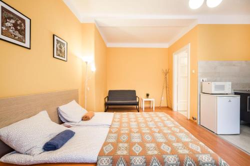 sypialnia z łóżkiem w pokoju z żółtymi ścianami w obiekcie BpR Cercle Point Apartment w Budapeszcie