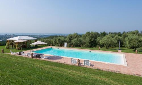 una gran piscina con sillas y sombrillas en Villa Sofia - Homelike Villas, en Amelia