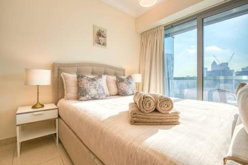 a bedroom with a bed with a large window at Prime Retreats- Downtown Dubai in Dubai