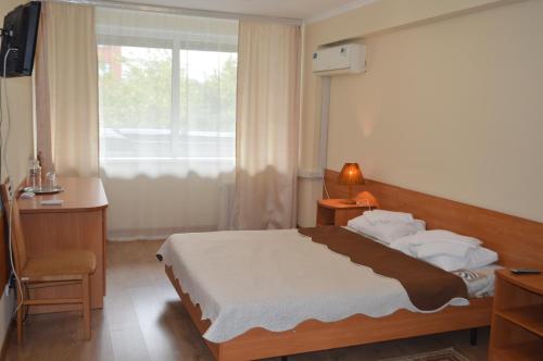 モスクワにあるホテル リーコンプのベッドルーム1室(ベッド1台、デスク、窓付)