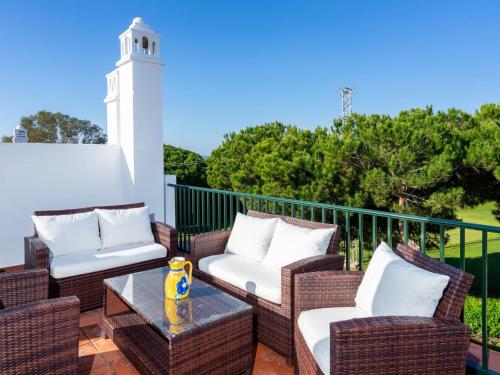 un patio con sillas de mimbre, una mesa y un faro en Holiday Home Los lomos de Cabopino, en Marbella
