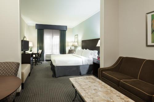 a hotel room with a bed and a couch at Holiday Inn Express Hotel & Suites New Iberia - Avery Island by IHG in New Iberia