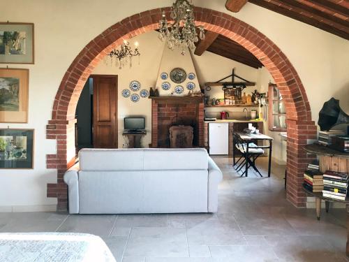 a living room with a white couch and a fireplace at Borgo San Gusmè in San Gusmè