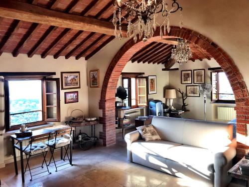 a living room with a couch and an archway at Borgo San Gusmè in San Gusmè