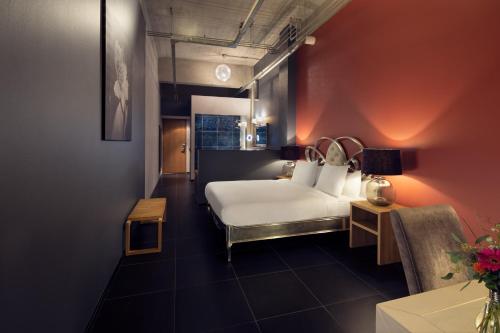 una camera d'albergo con letto e sedia di WestCord Hotel Eindhoven a Eindhoven