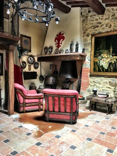 a living room with two chairs and a fireplace at Borgo San Gusmè in San Gusmè