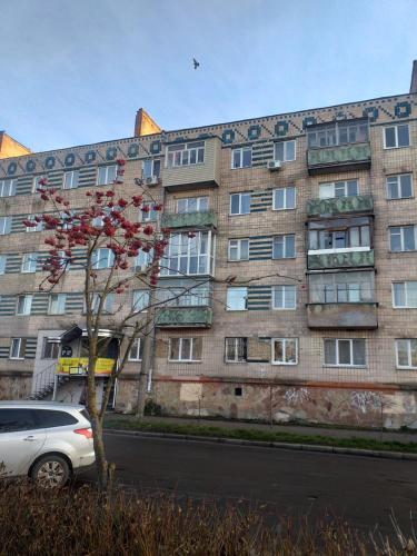 un edificio con un coche aparcado delante de él en Rusalika, en Rivne