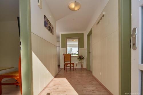a hallway of a house with a chair and a table at Heikes Frühstückspension in Padenstedt