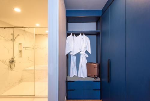 a bathroom with blue walls and a glass shower at Amanta Hotel & Residence Sathorn in Bangkok