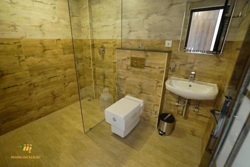 a bathroom with a sink and a shower and a toilet at Moonline Resort in Anaviratty