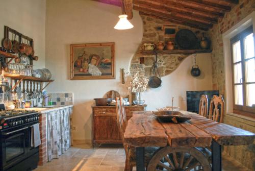 a kitchen with a wooden table and a stove at Borgo San Gusmè in San Gusmè