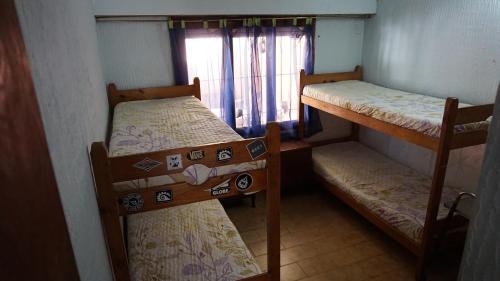 ein kleines Zimmer mit 2 Etagenbetten und einem Fenster in der Unterkunft casa emilia in Villa Gesell