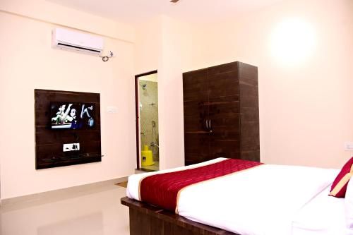 a bedroom with a bed and a tv on the wall at The INN in Mysore