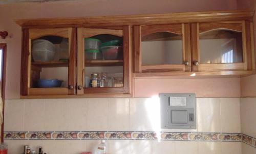 a kitchen with wooden cabinets and a microwave at Breathtaking Volcan Mountain/River Views in Volcán