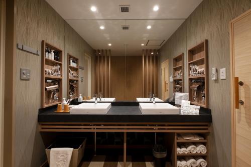 a bathroom with two sinks and a large mirror at HOTEL MYTH-WA -ホテル マイス ワ- adult only in Wakayama