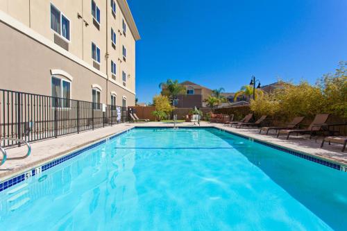 a swimming pool in front of a building at Holiday Inn Express Hotel & Suites Los Angeles Airport Hawthorne by IHG in Hawthorne